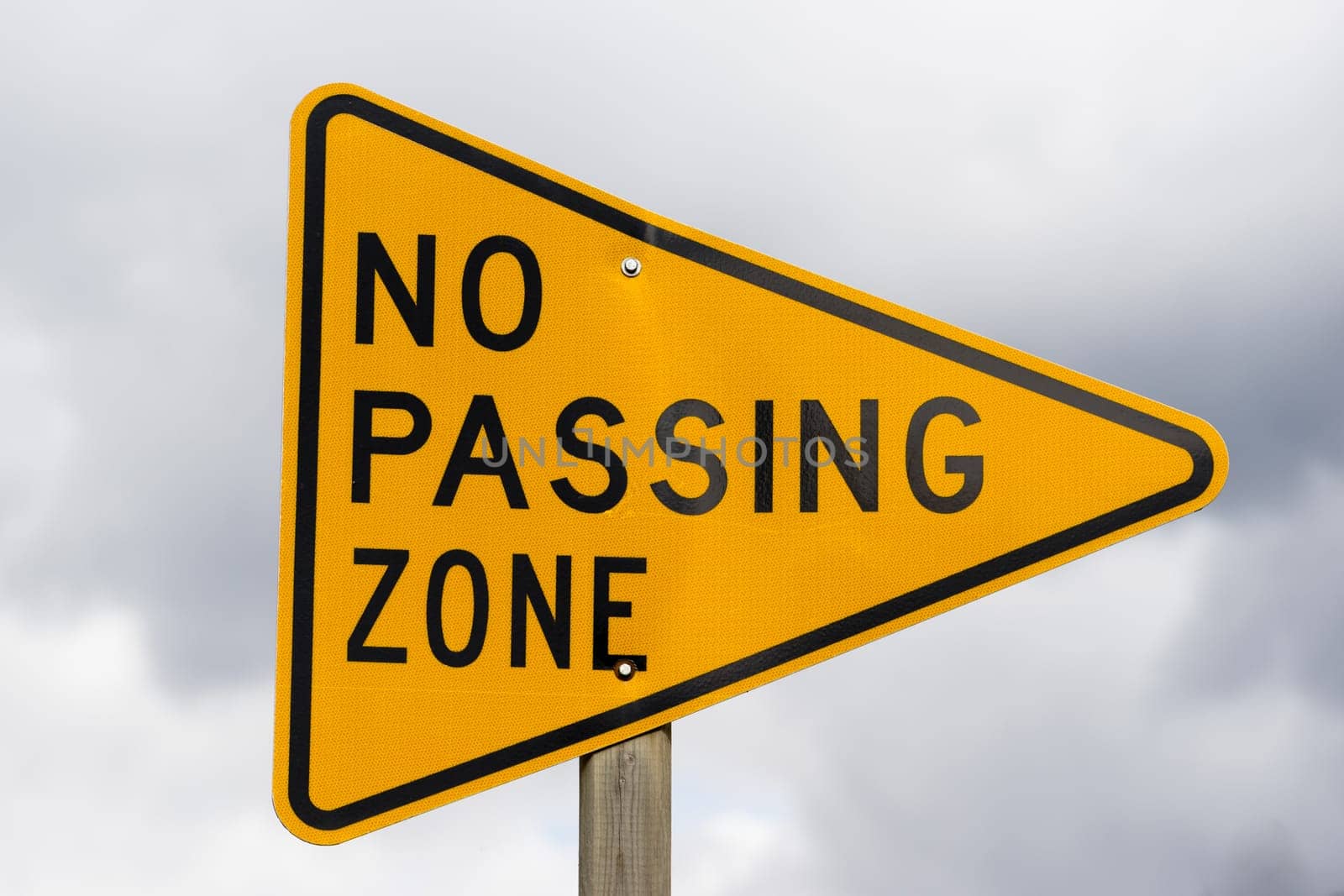 a reflective sign bolted to a post says no passing zone