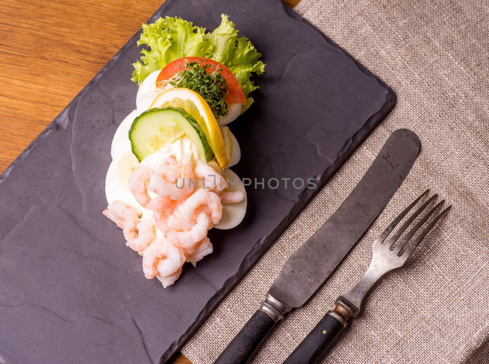 Danish specialties and national dishes, high-quality open sandwich. Boiled Egg, Shrimps, mayo, cucumber and lemon served on a plate and ready for eating