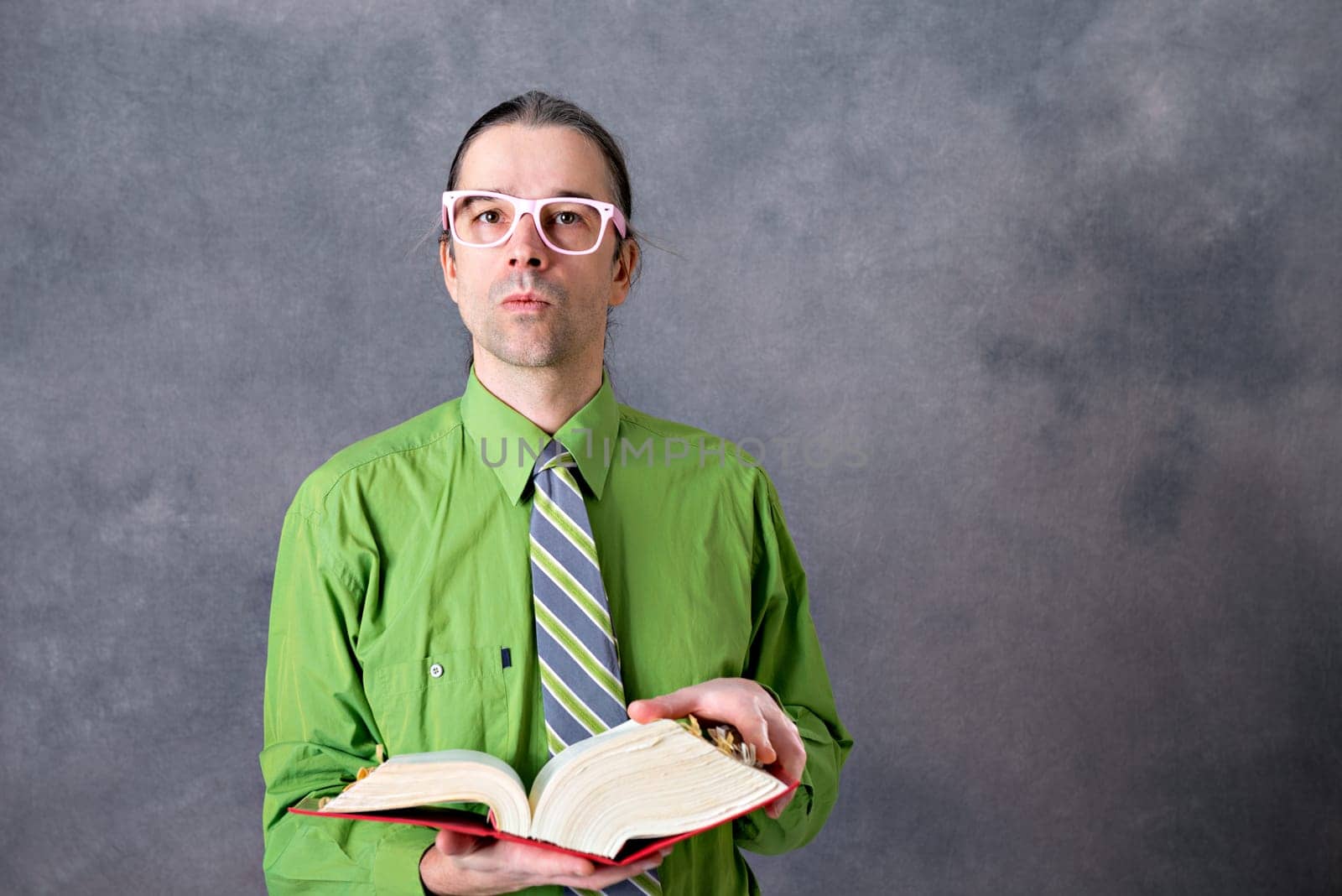angry lawyer in green shirt and necktie with statute book and pink glasses