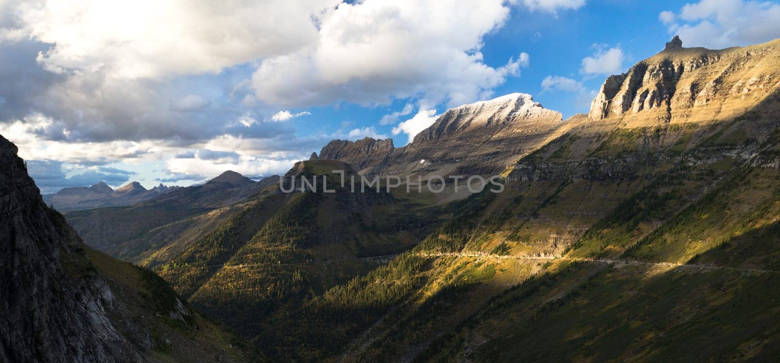 High peaks of the rocky mountains loom over the highway in Glacier National Park