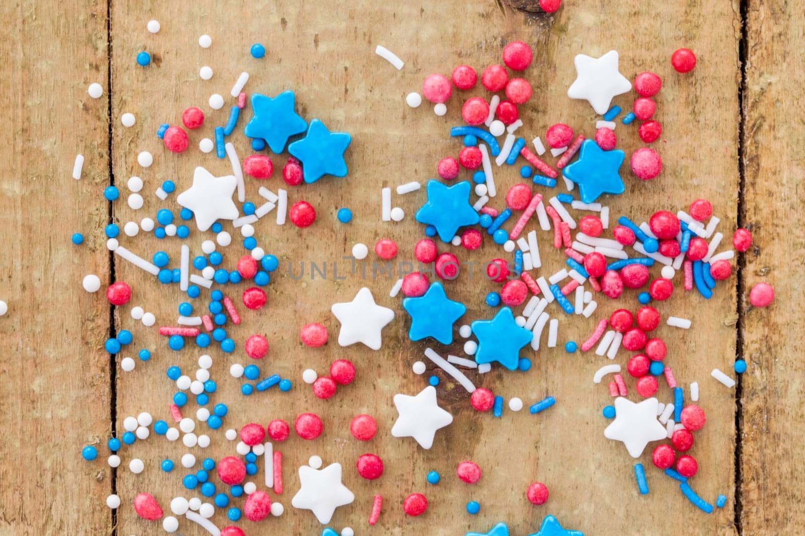 Colorful sugar sprinkles in red,white and blue on a rustic wooden background