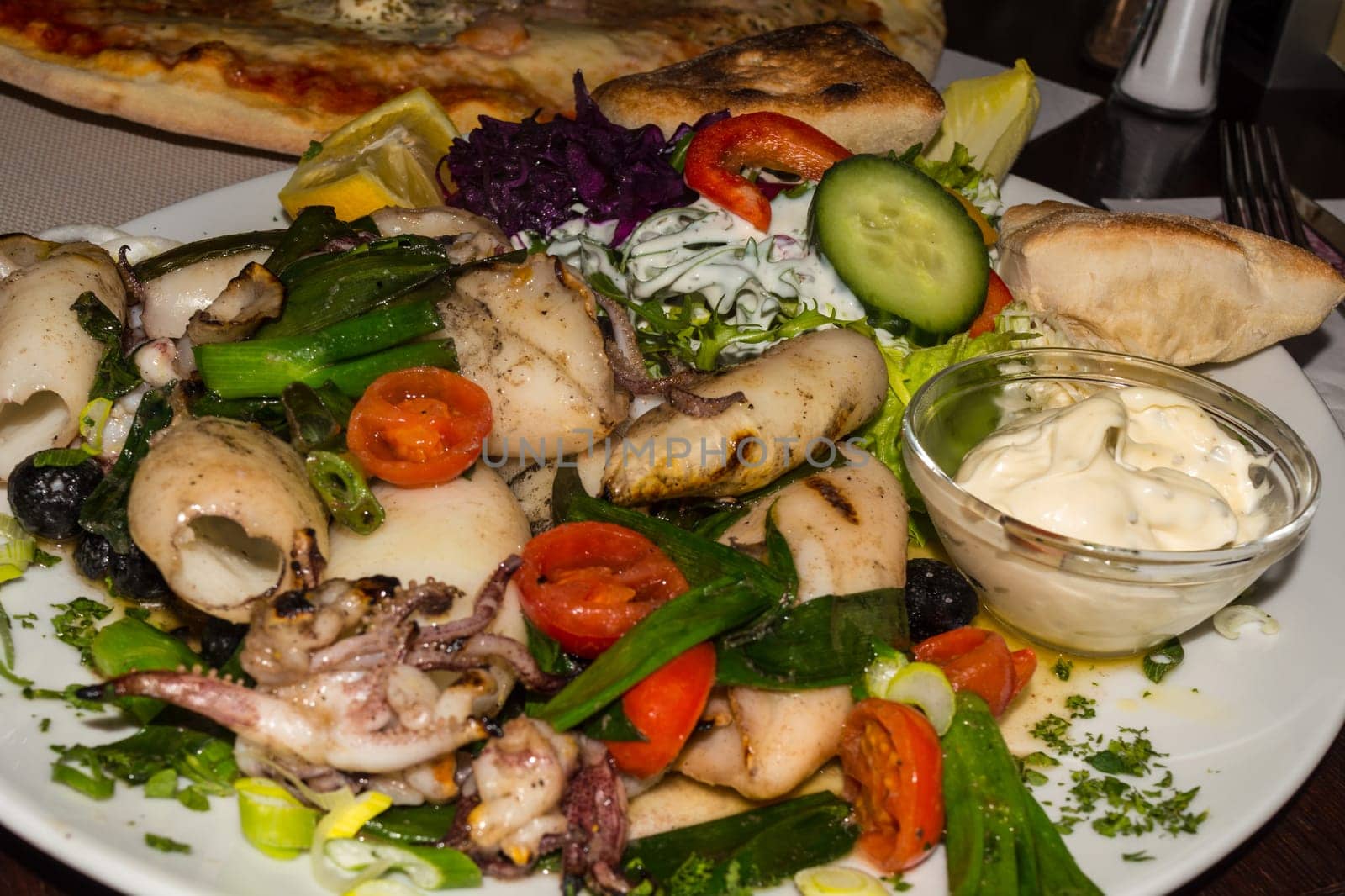 Grilled squid with side dishes,bread and salad..