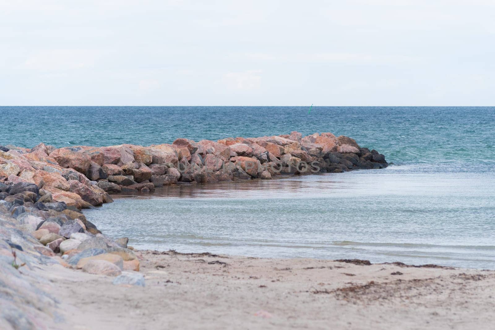 small sea barrier made of stones at the north side of sealand, denmark