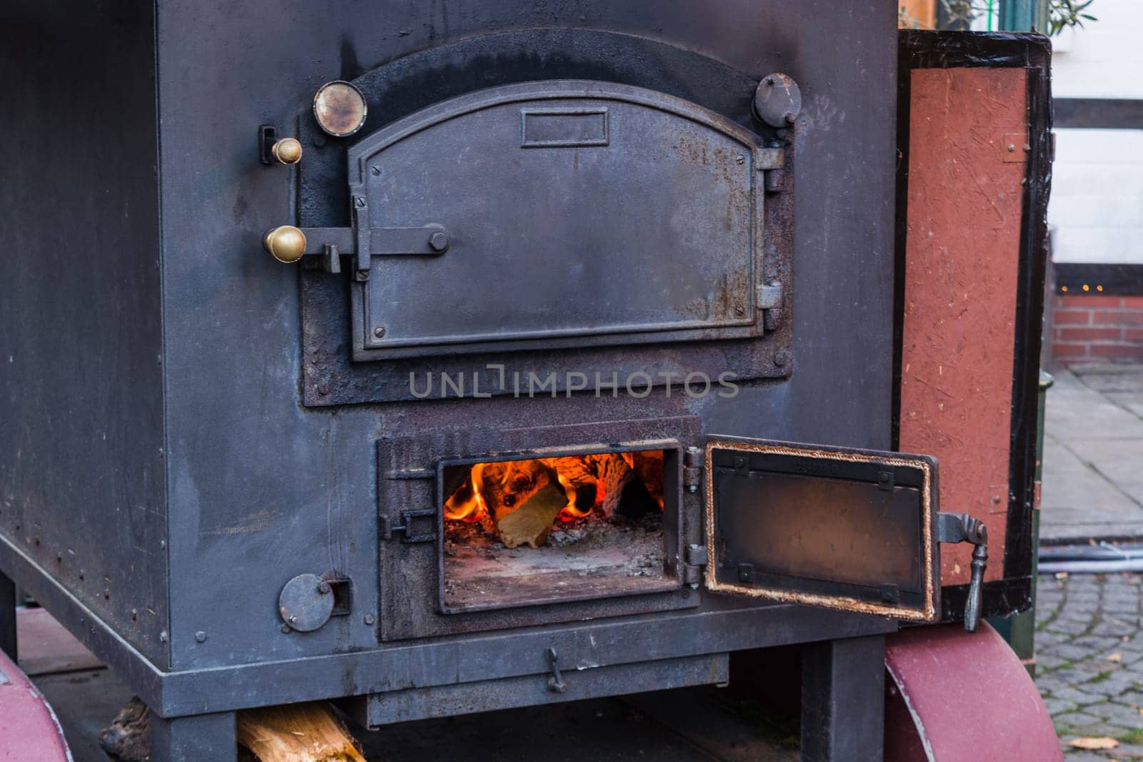 Indoor fireplace in a corner with firewood and axe in an old country house..