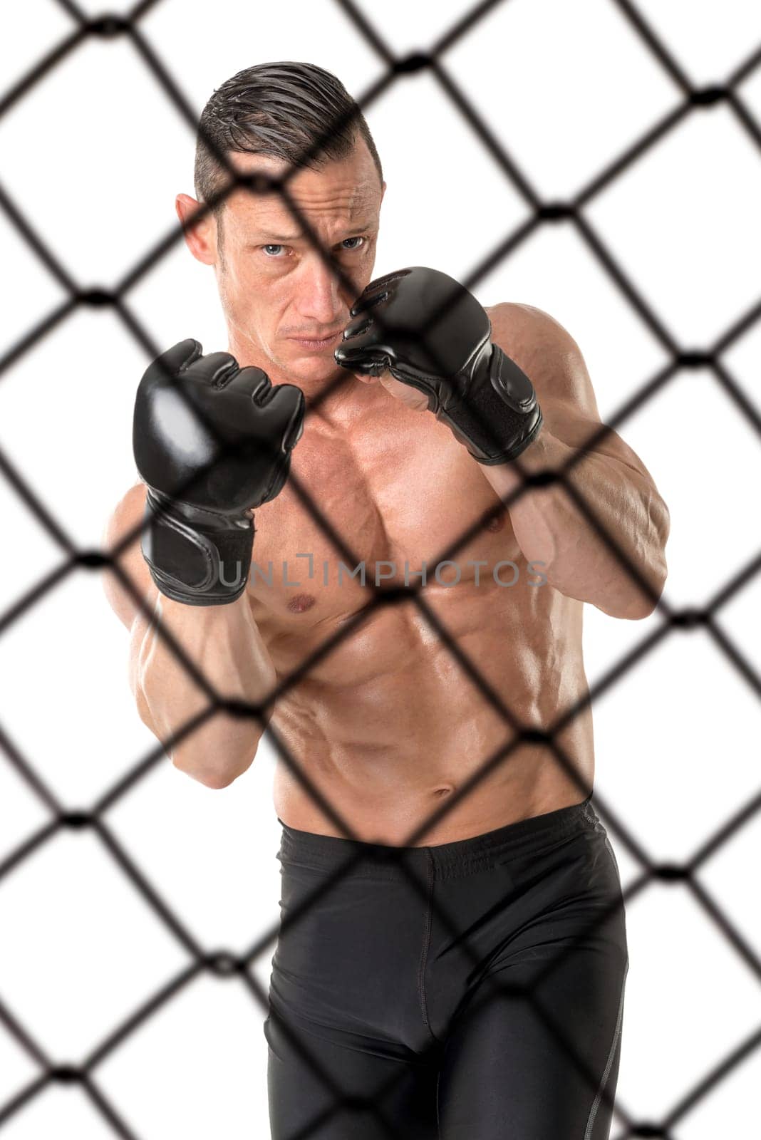 Strong Mixed Martial Arts fighter inside the cage isolated in white