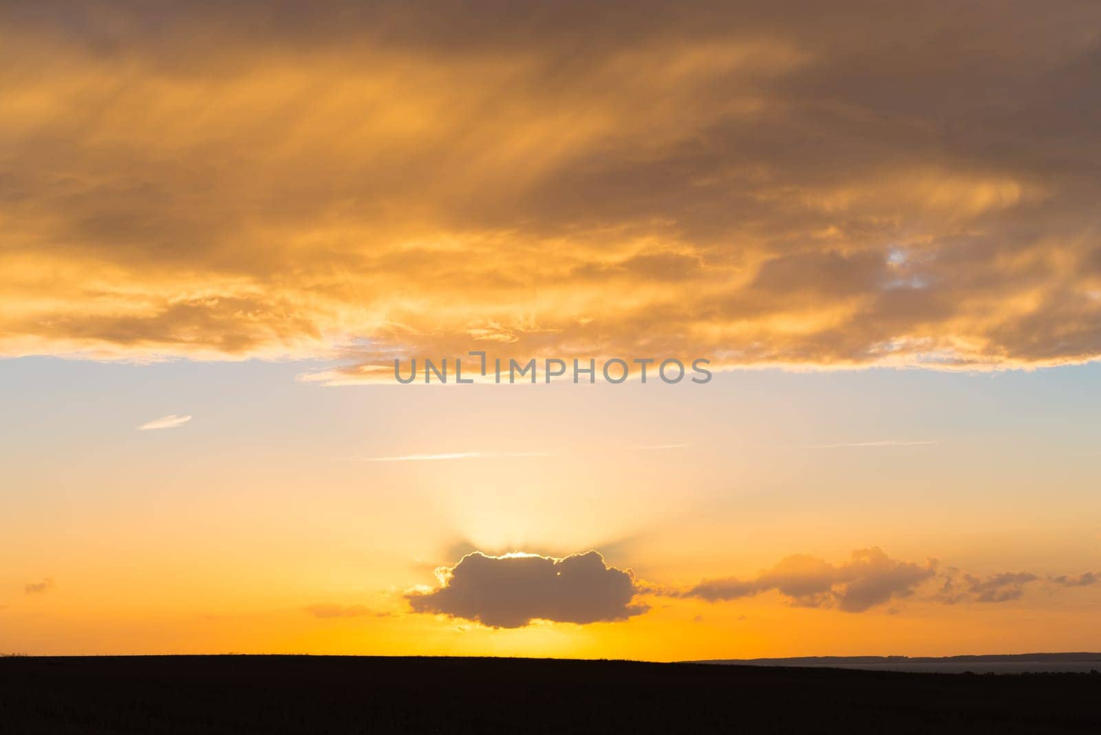 beautiful orange sunset with a sun behind a single cloud