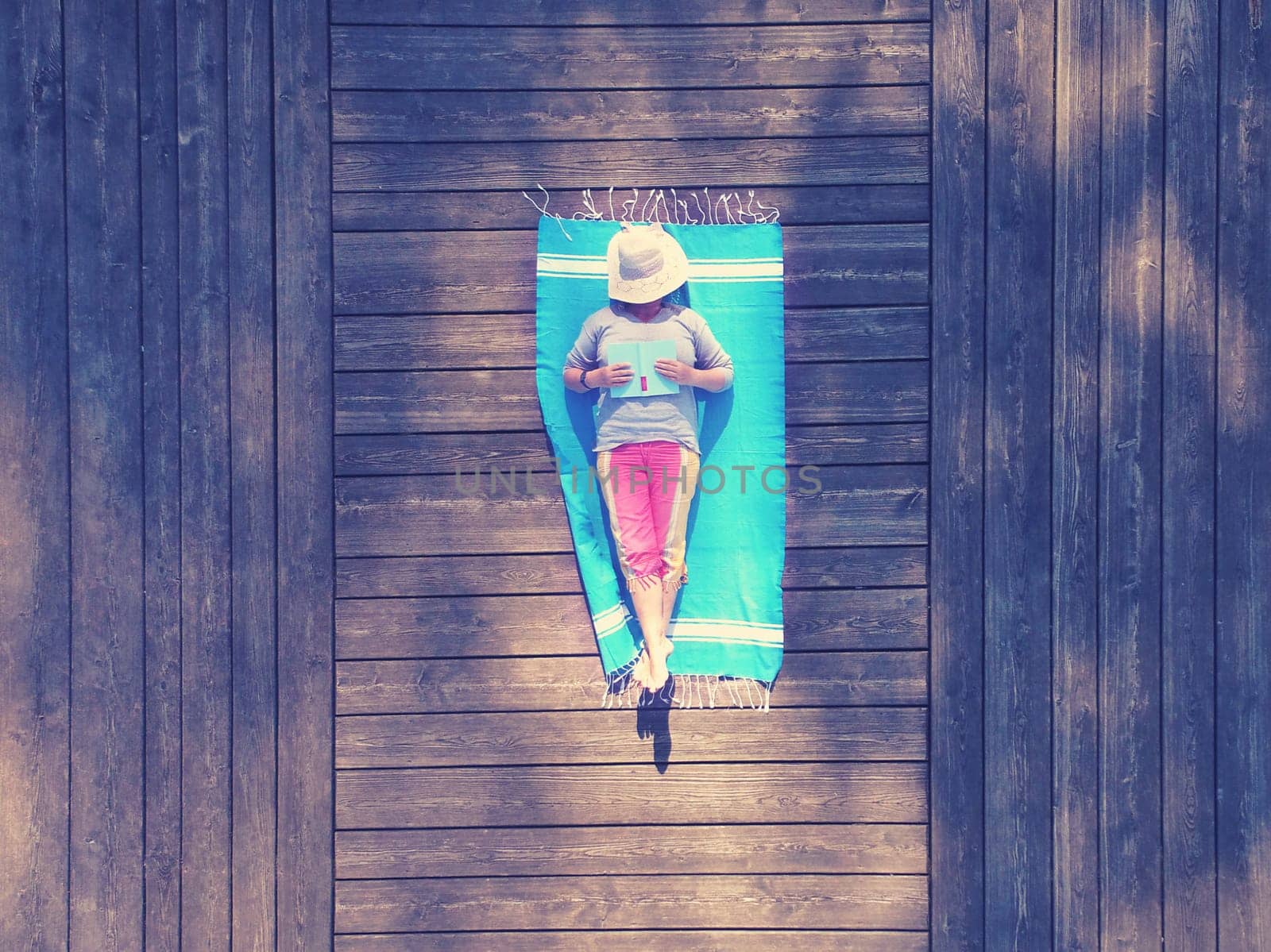 Drone recording - Senior citizen with book at the jetty at the lake