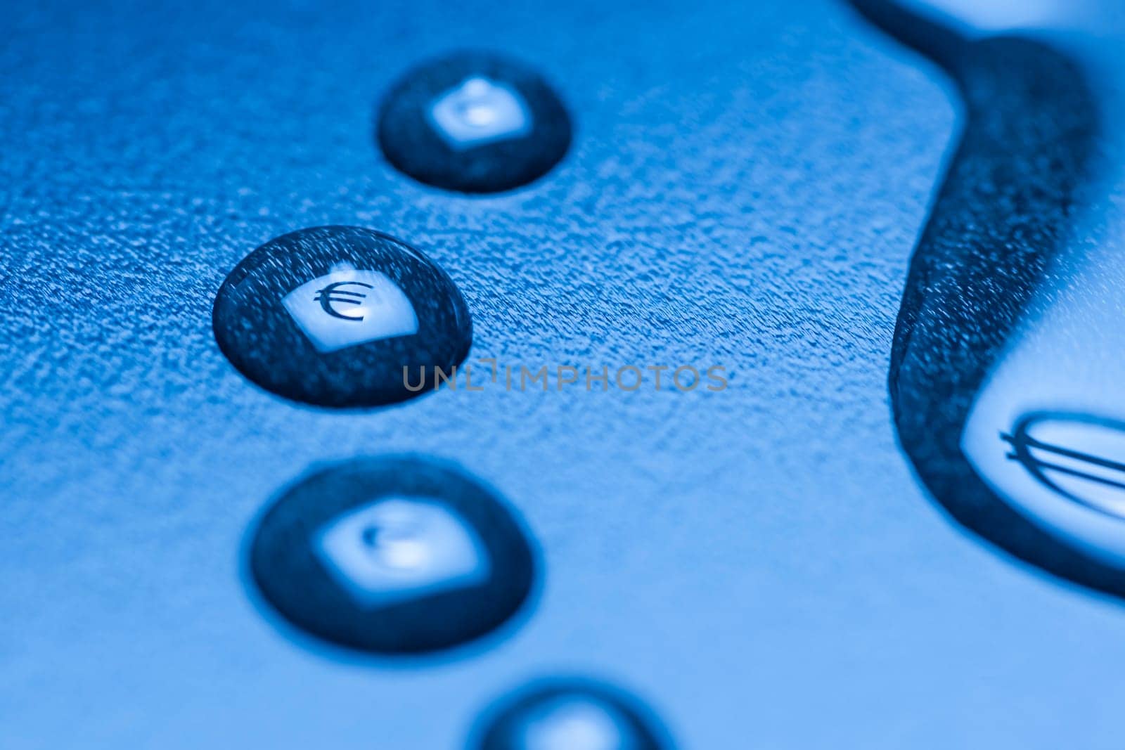One larger cut liquid drop and several smaller ones with mirrored EURO symbol on blue background.