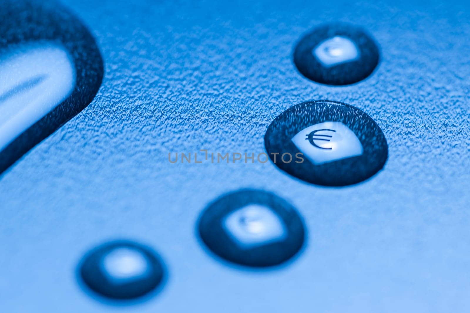 One larger cut liquid drop and several smaller ones with mirrored EURO symbol on blue background.