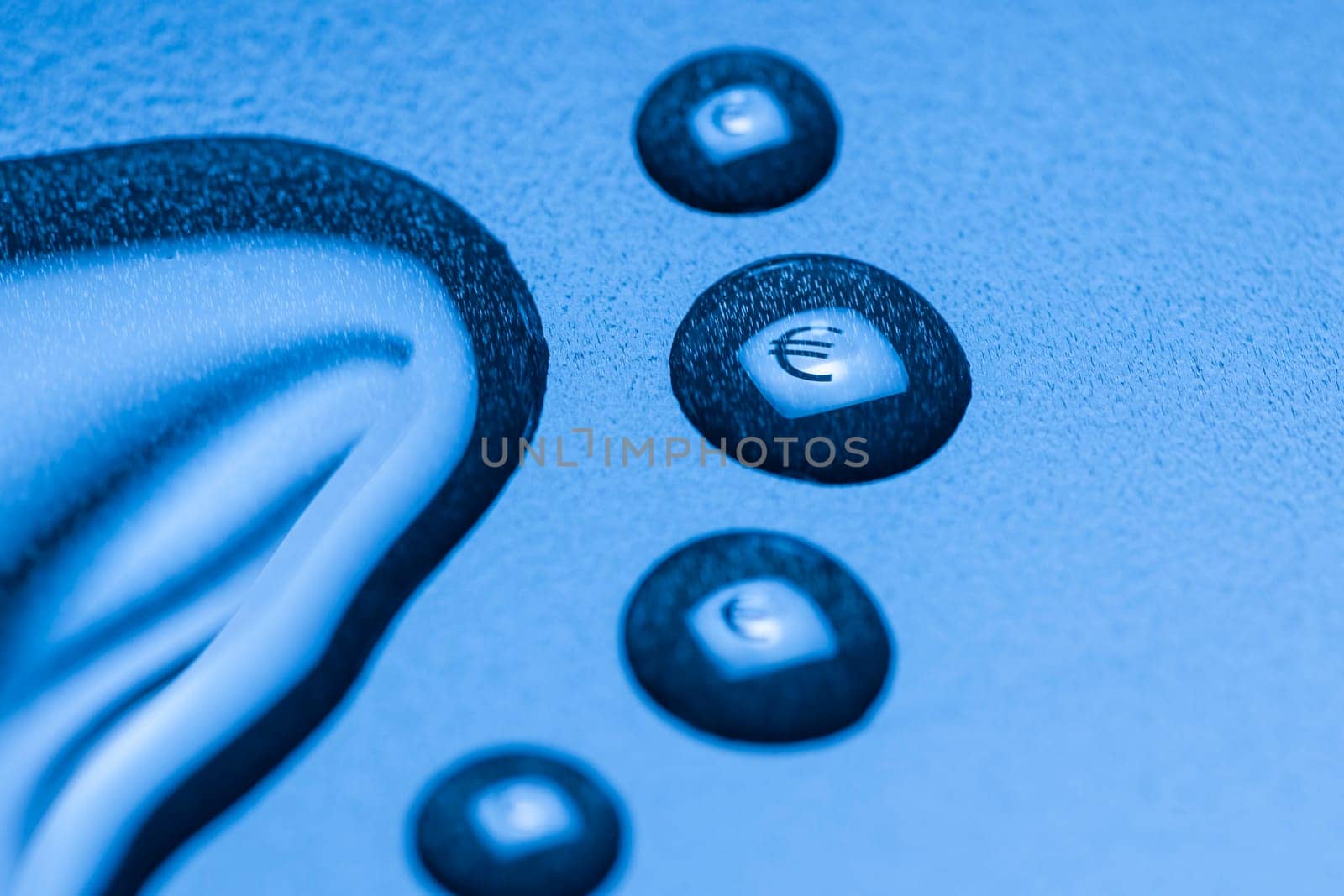 One larger cut liquid drop and several smaller ones with mirrored EURO symbol on blue background.