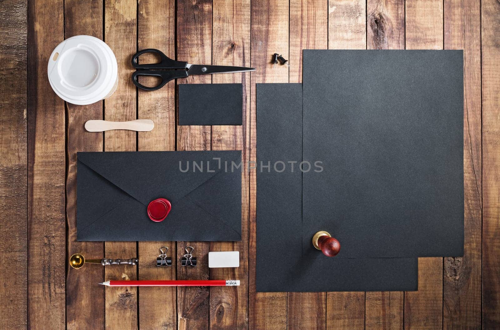 Photo of blank black stationery set on vintage wooden table background. Template for placing your design. Mockup for branding identity. Top view.