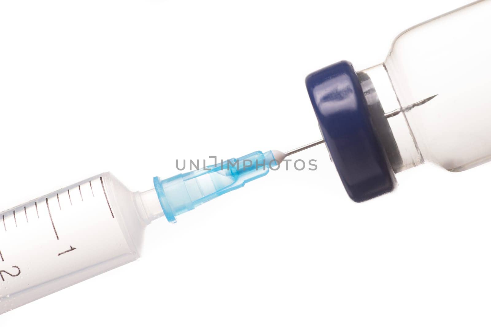 Syringe, needle and medicine vial. The needle sticks through the sterile membrane into the clear liquid.