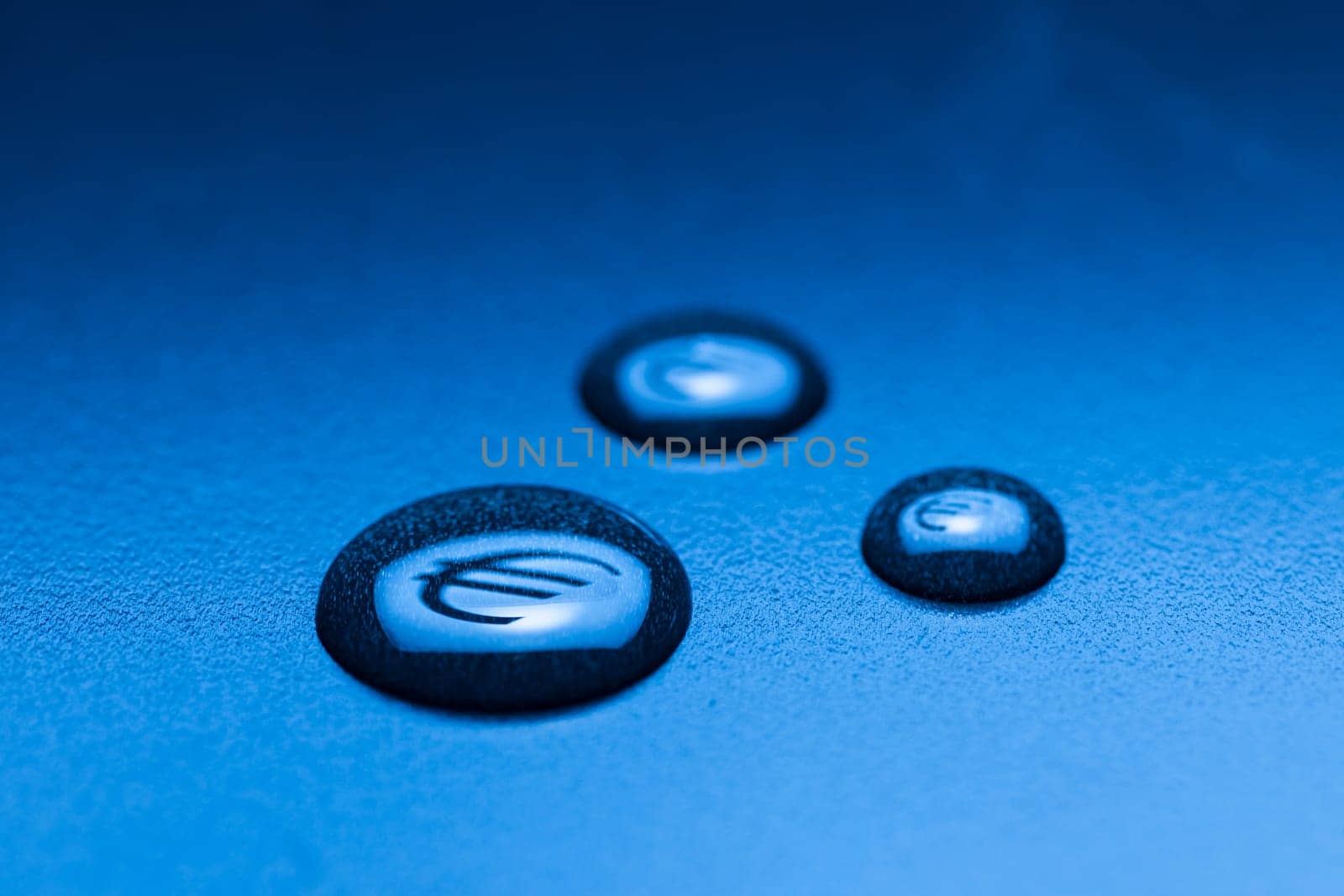 Three liquid drops with mirrored EURO symbol on a blue background with gradient.