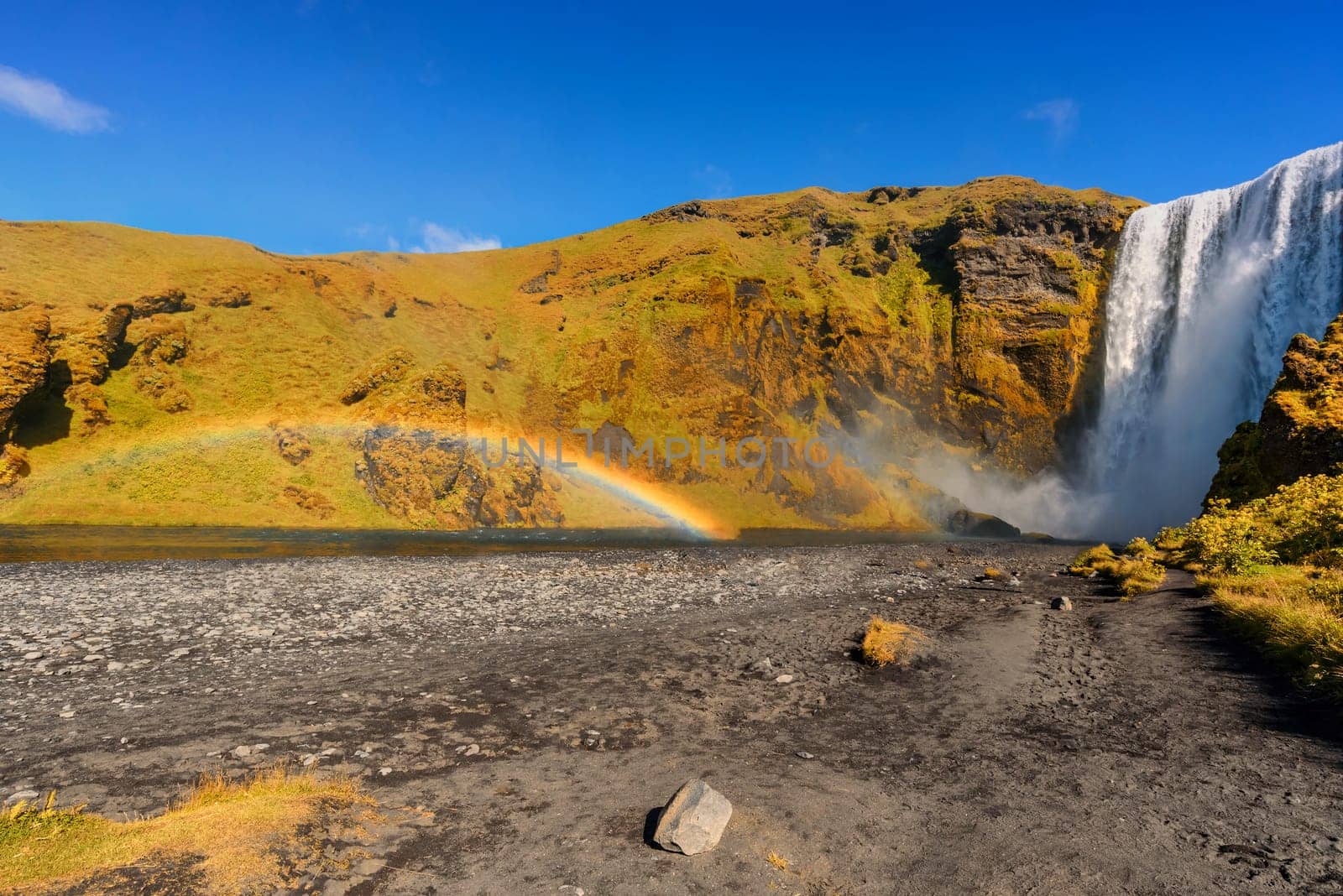 beautiful waterfall Skogafoss with rainbow, famous natural landmark in Iceland, hot summer effect