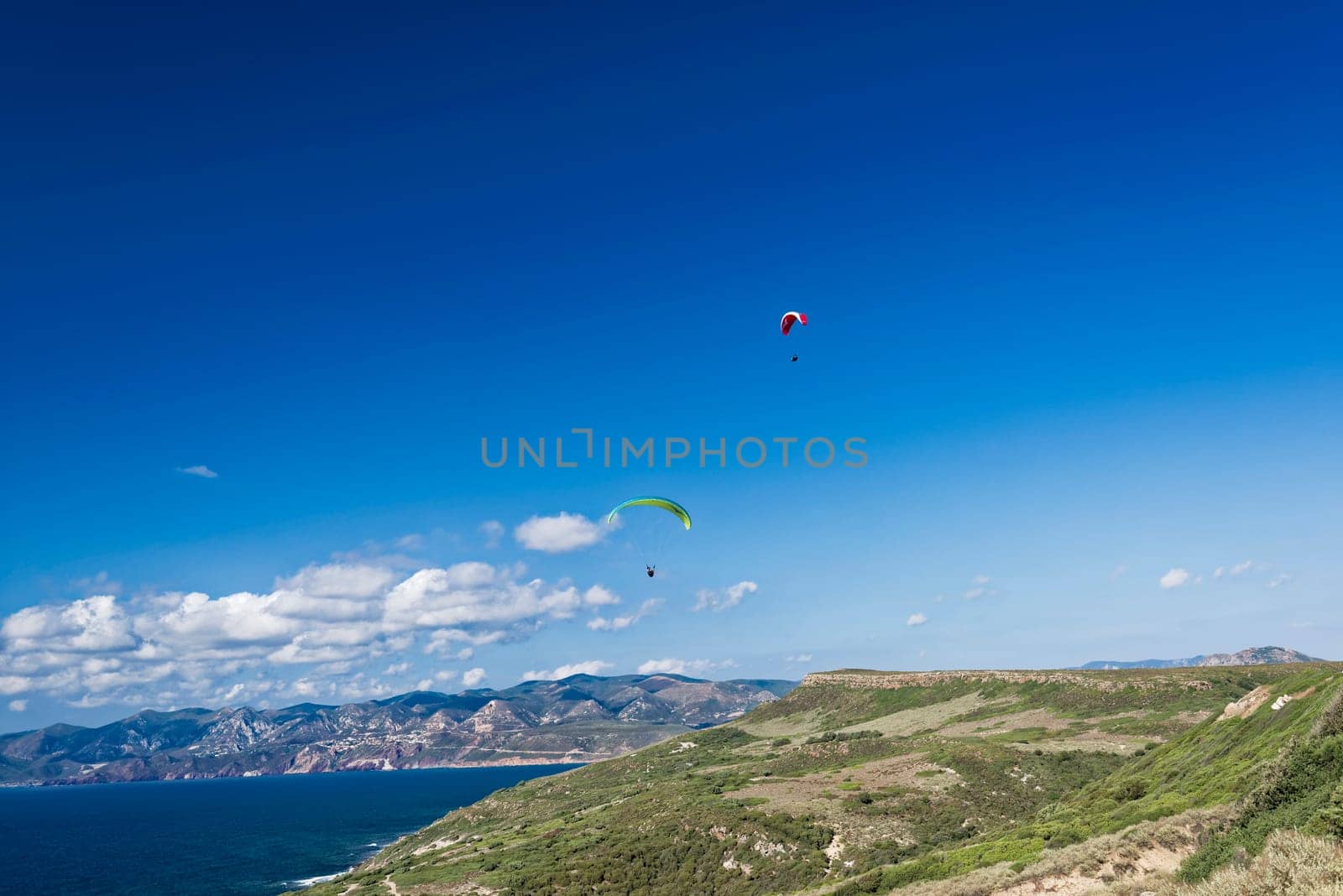 Colorful hang glider in sky over blue sea