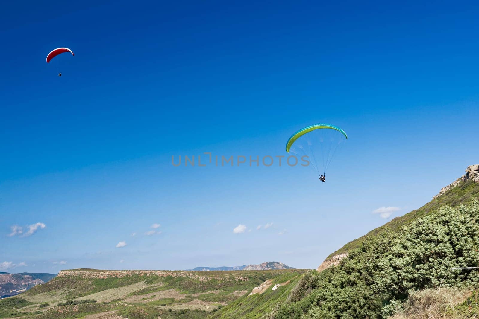 Colorful hang glider in sky over blue sea