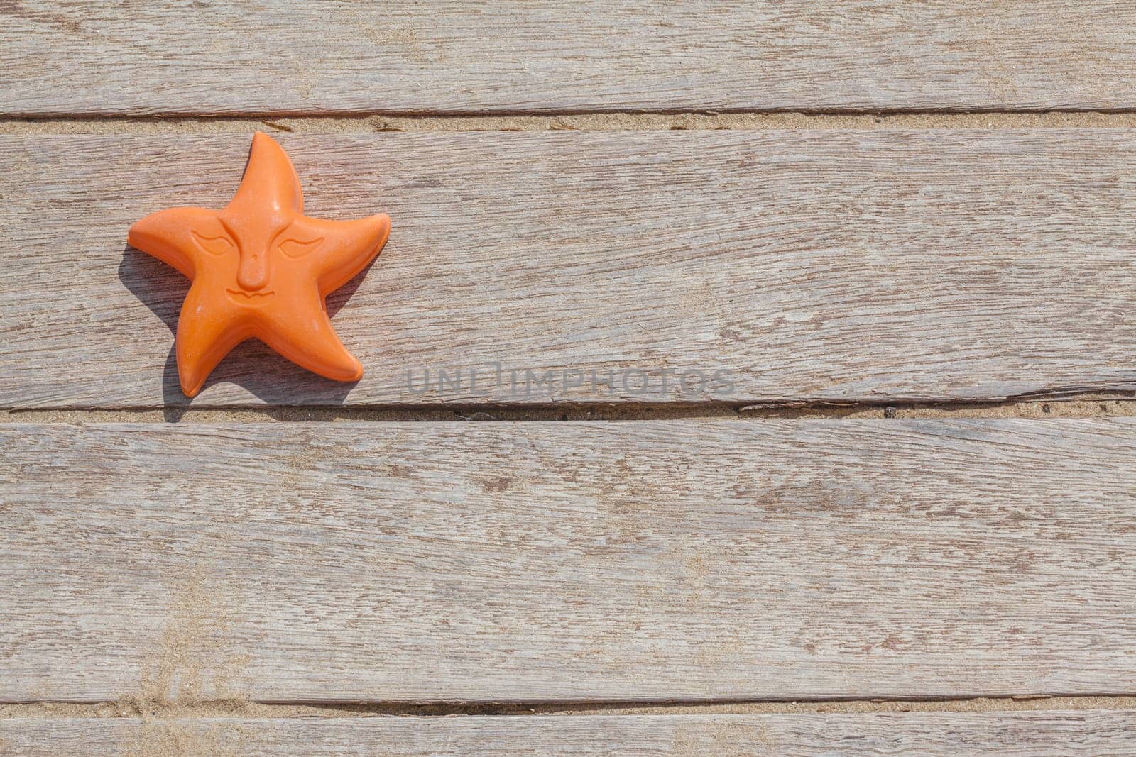 Children beach toy isolated on wood background on a sunny day