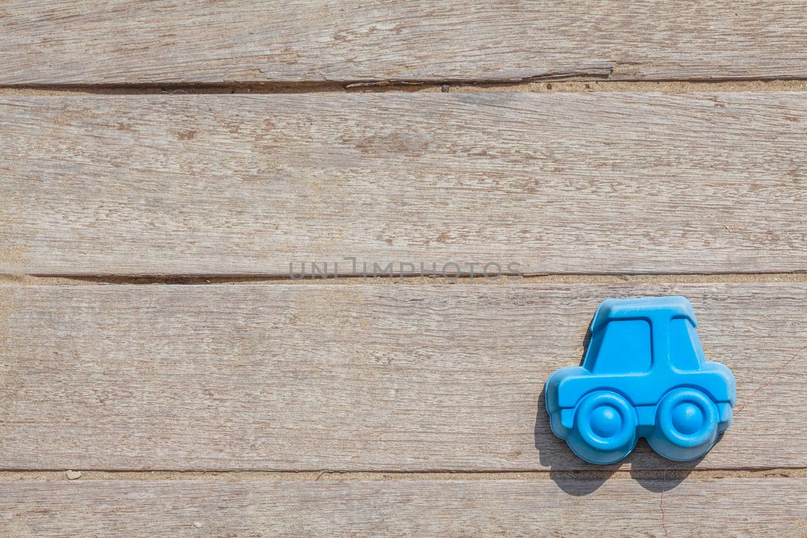 Children beach toy isolated on wood background on a sunny day