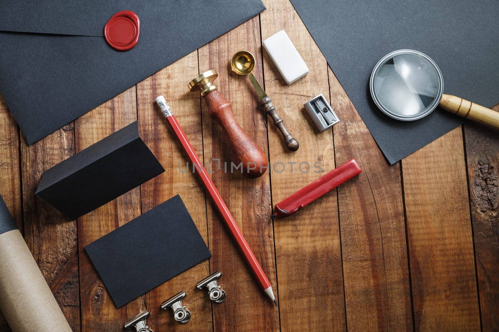 Blank branding template on vintage wooden table background. Photo of blank black stationery. Mock-up for design portfolios. Top view.