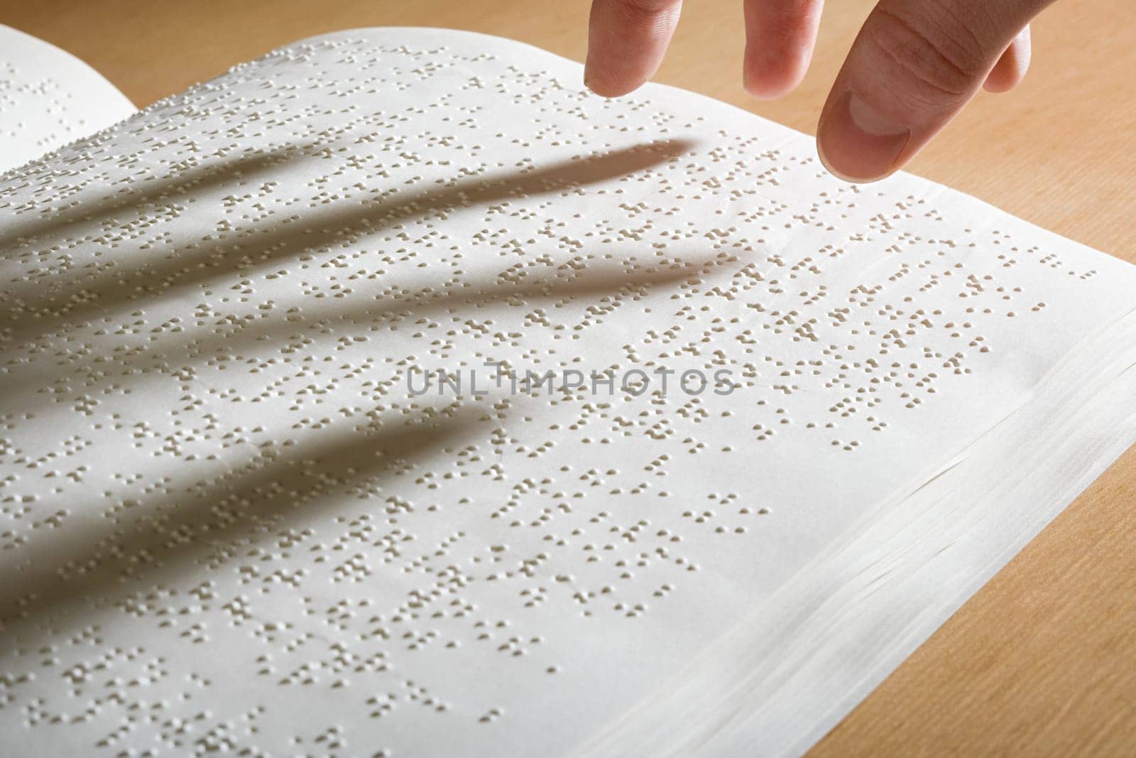 Fingers above a braille book