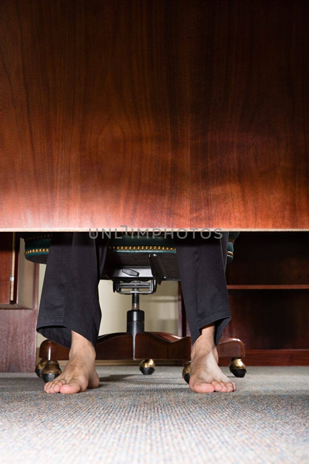 Feet of businessman under desk