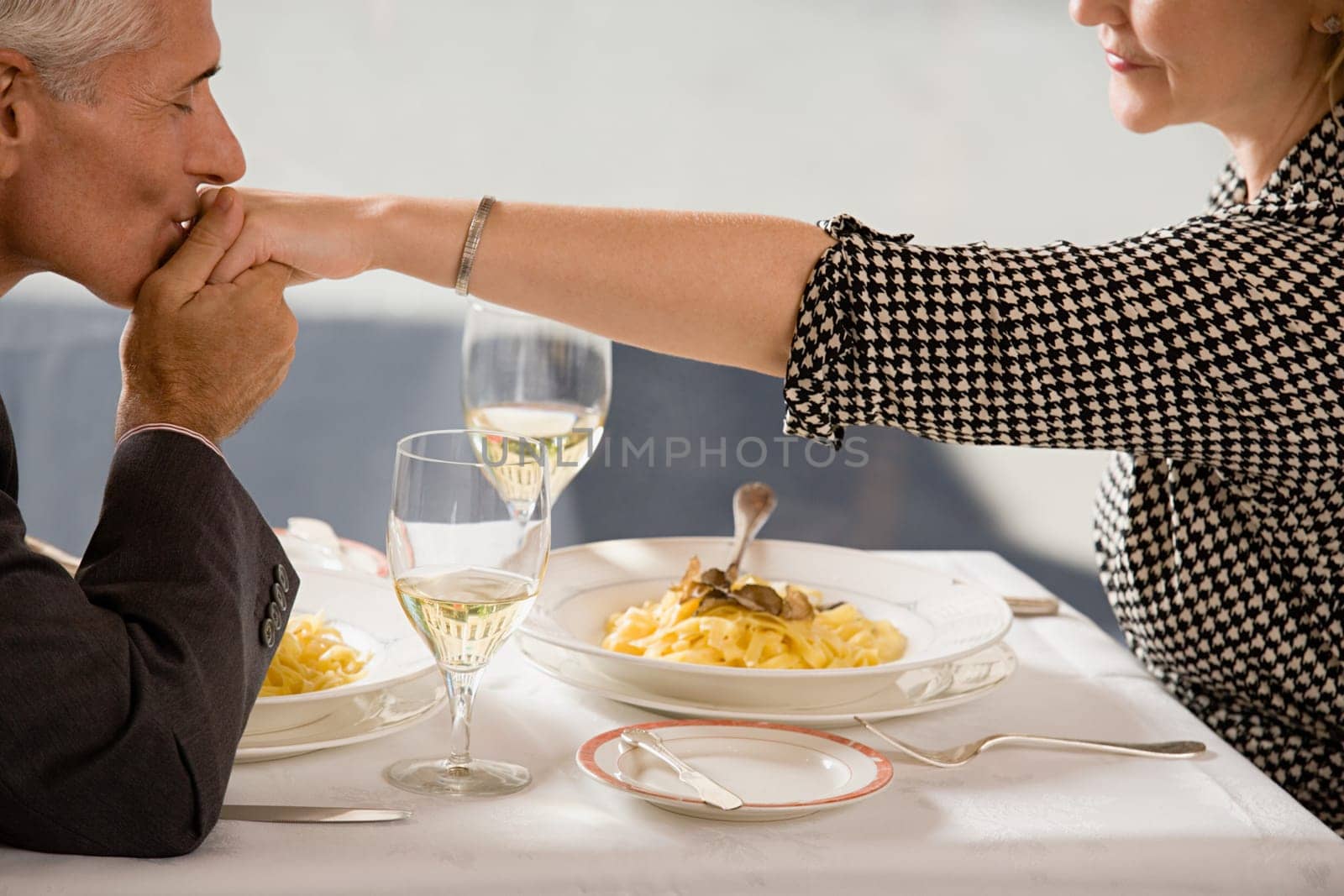 Man kissing woman's hand