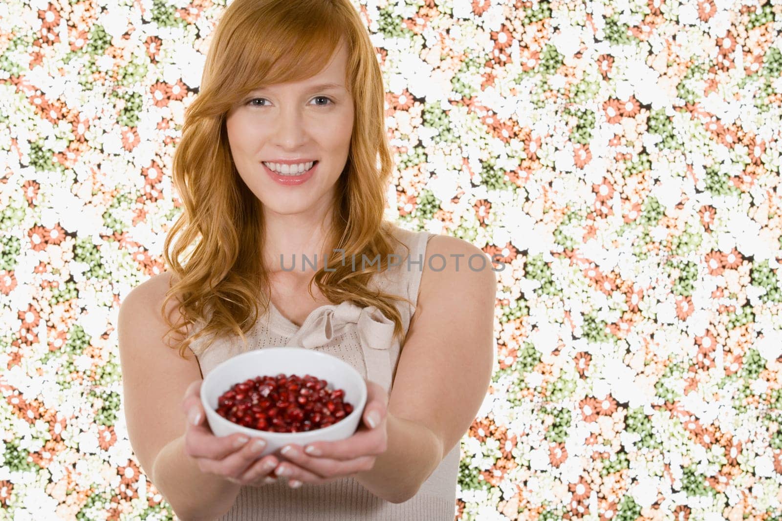 Woman holding bowl of pomegranate seeds