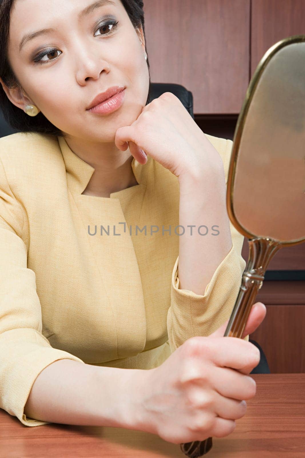 Businesswoman looking at mirror