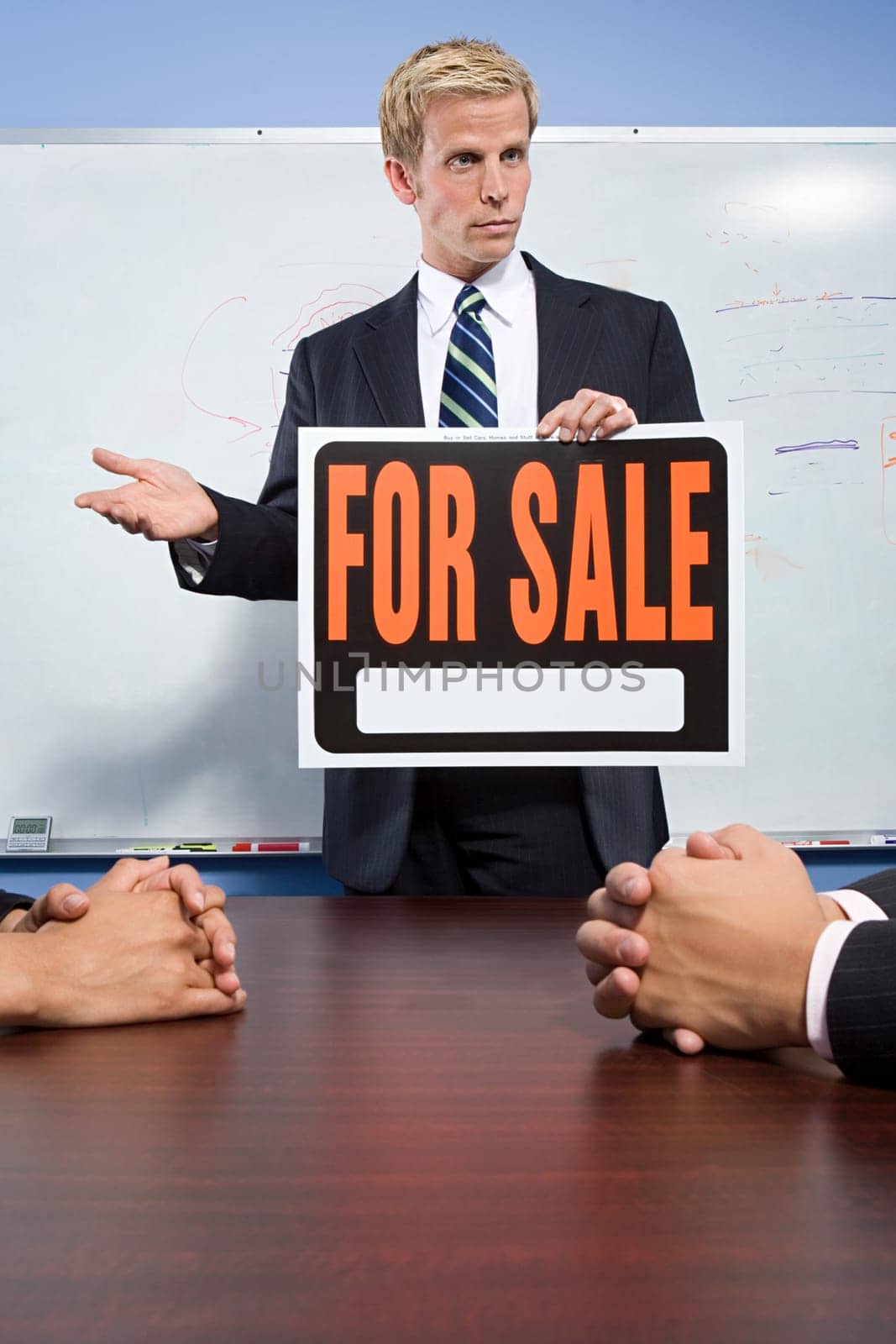 Businessman holding for sale sign