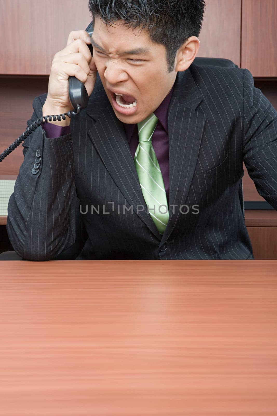 Businessman shouting down phone