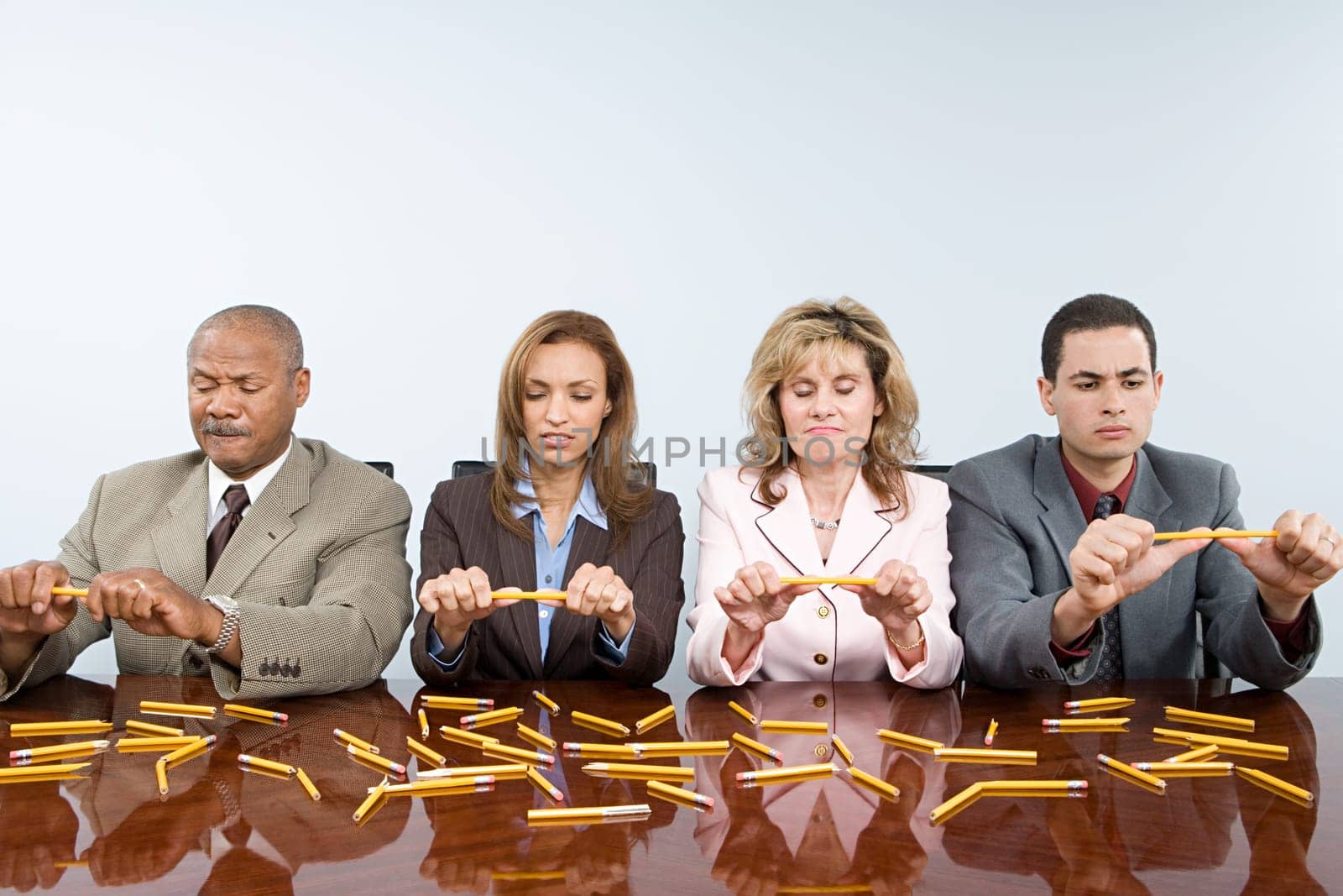 Businesspeople breaking pencils