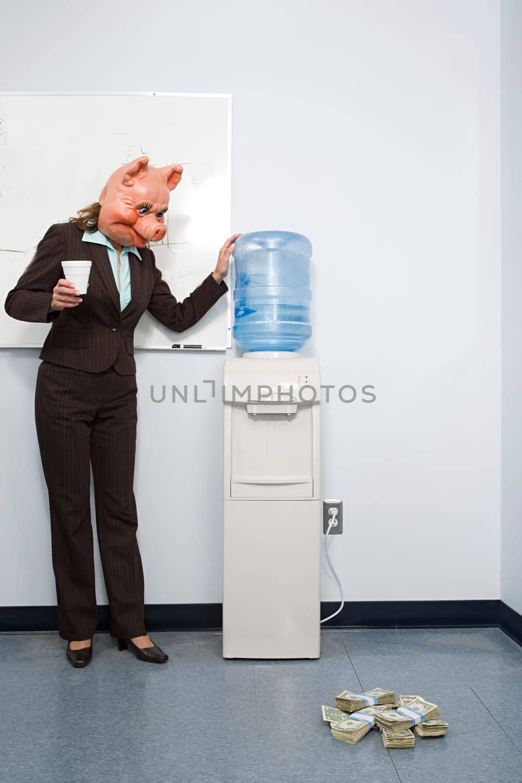 Businesswoman in pig mask looking at money