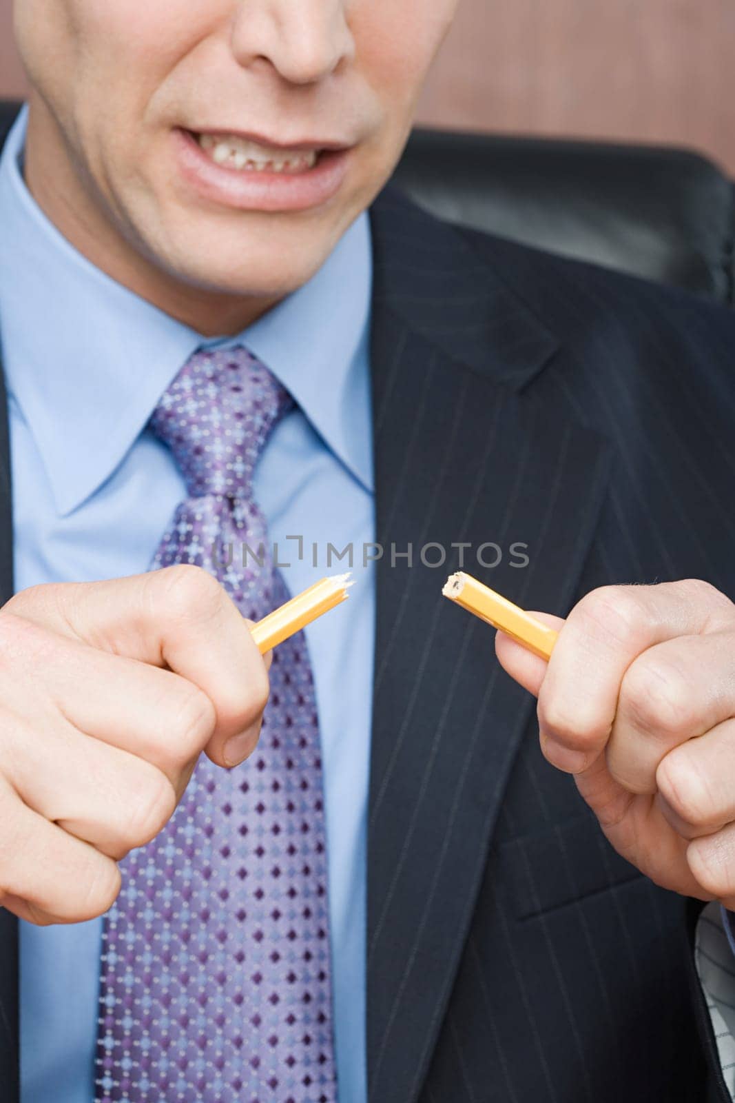 Businessman breaking pencil