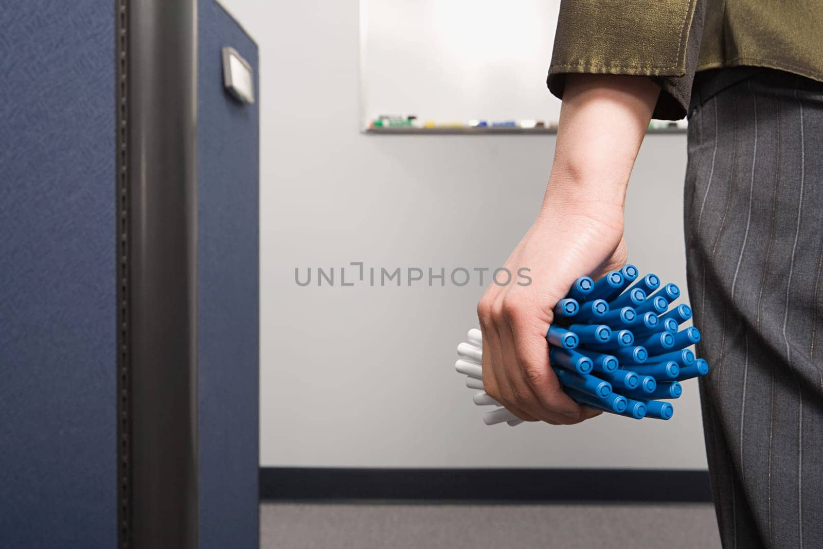 Office worker holding lots of pens