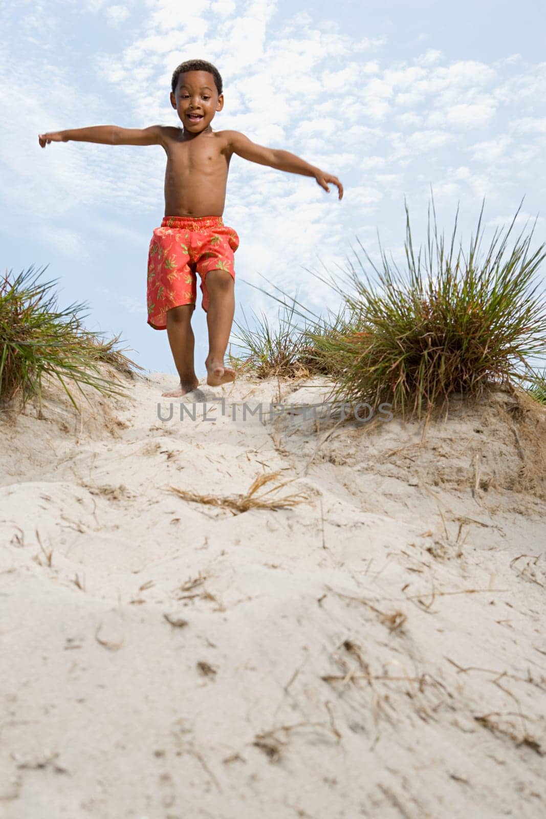 Boy walking down dune