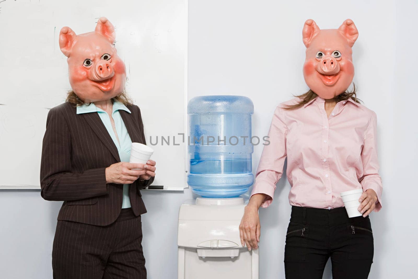 Two businesswoman in pig masks at a water cooler