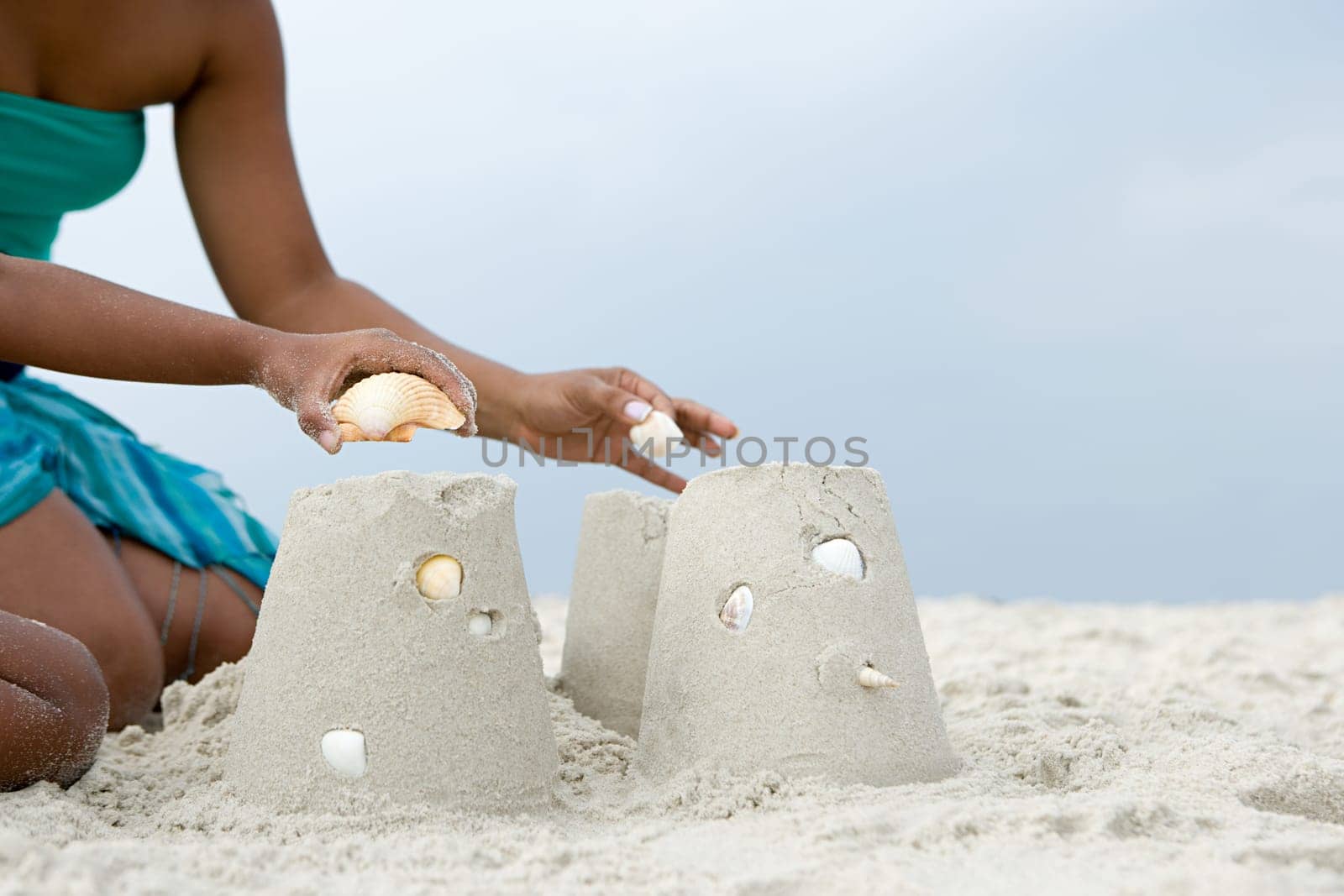 Mother and child putting shells on sandcastles