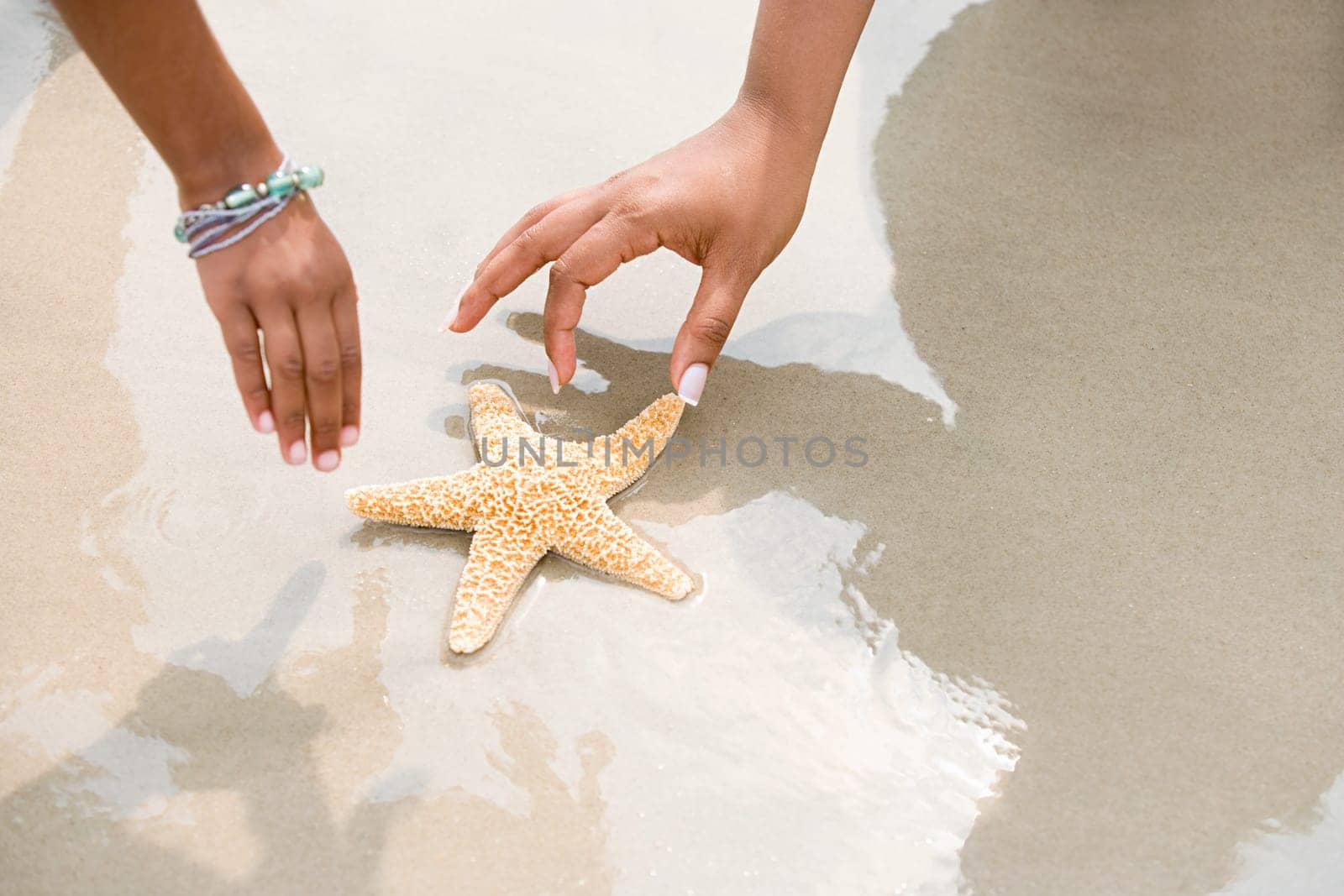Mother and daughter picking up starfish