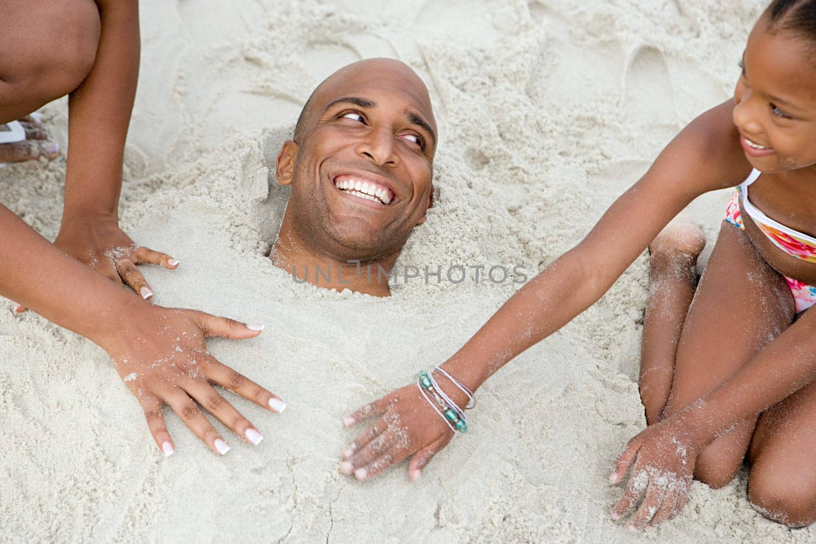 Family burying father in sand