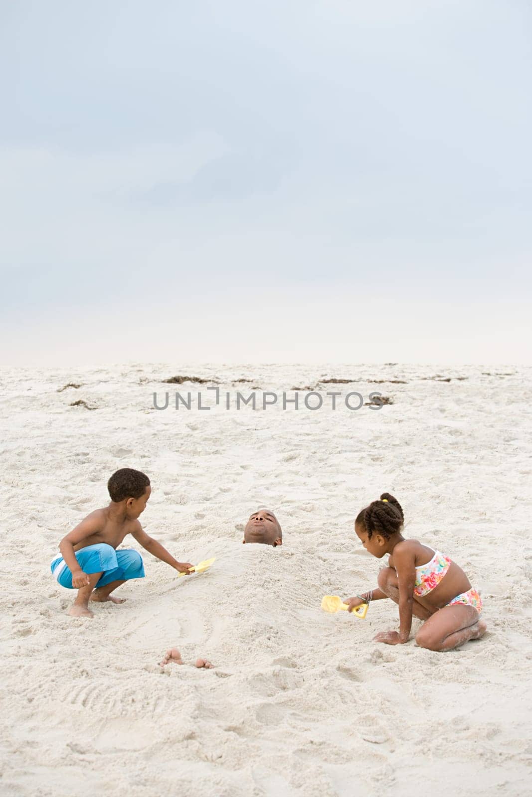 Children burying father in sand
