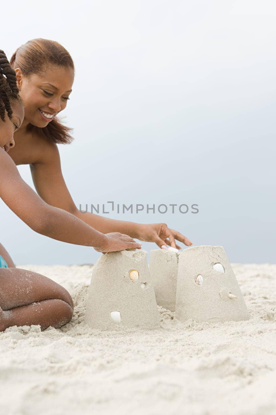 Mother and daughter making sandcastles