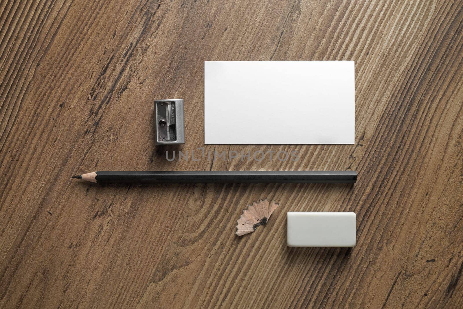Bank business card, pencil, eraser and sharpener on wood table background. Template for ID. Responsive design mockup. Top view.