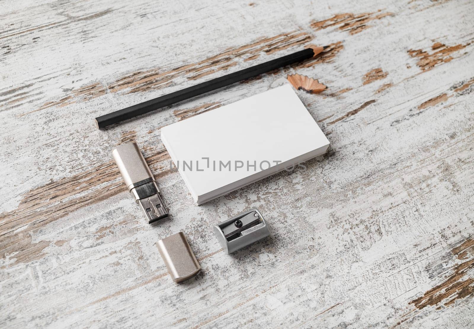 Bank white business cards, pencil, flash drive and sharpener on vintage wood table background. Mock-up for branding identity. Blank template for design presentations and portfolios.
