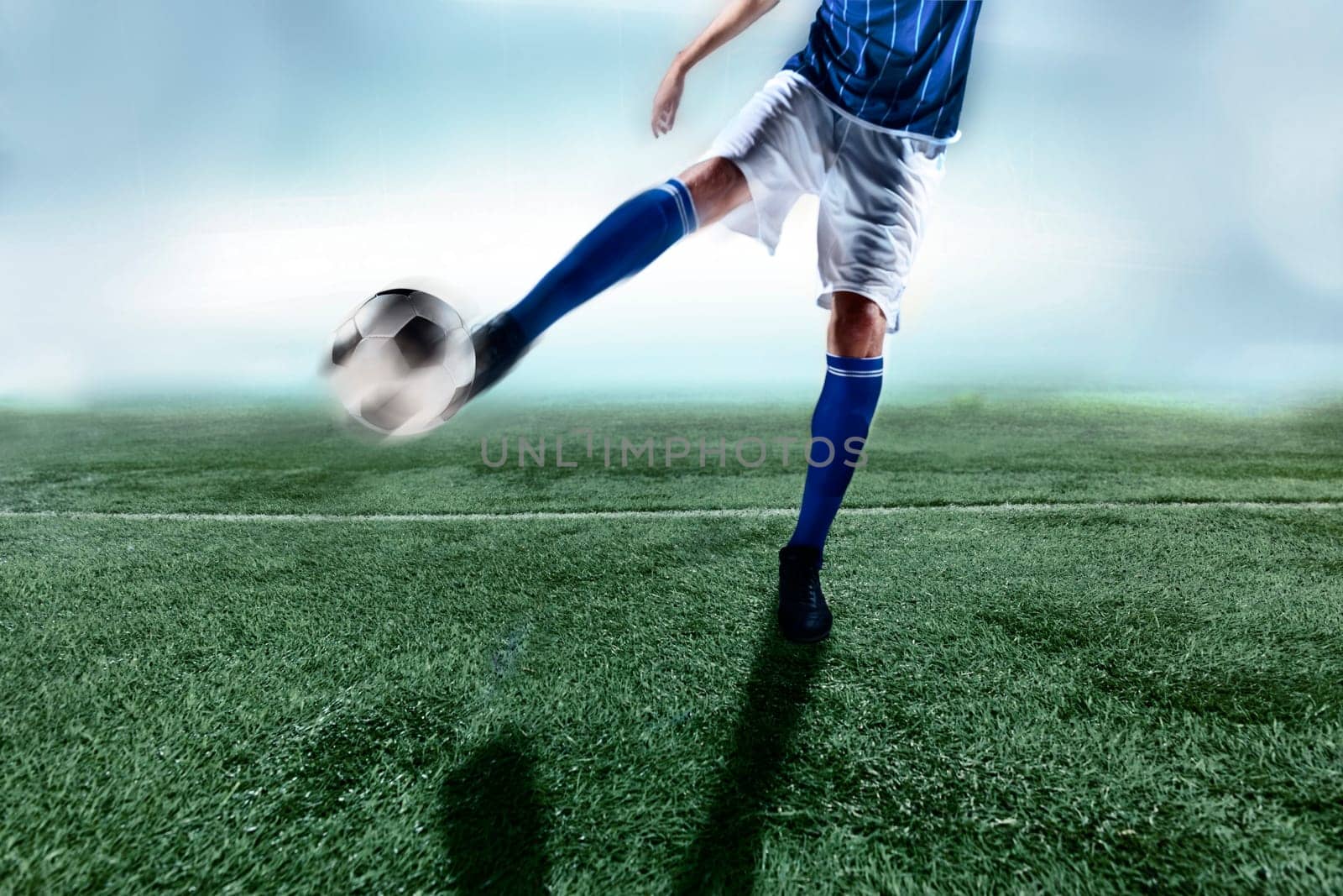 Athlete kicking soccer ball