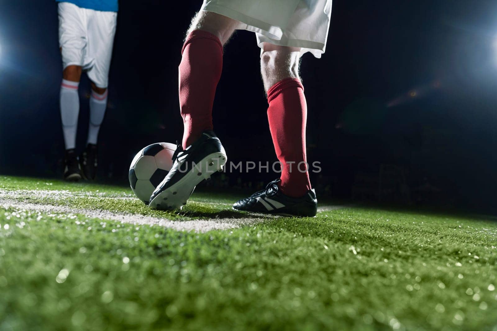 Two soccer players kicking a soccer ball