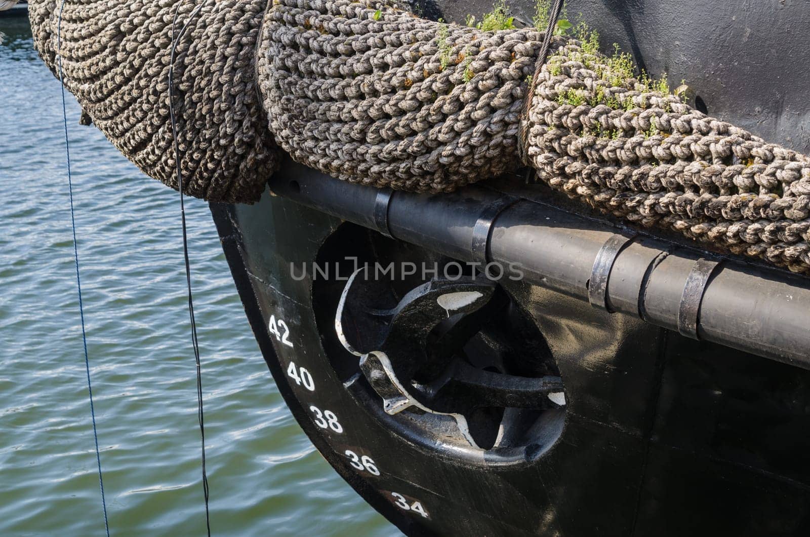 Old rusty anchor at a board of the ship