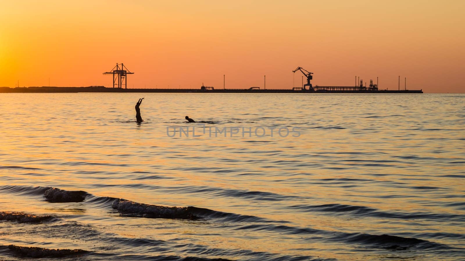 Couple bathing at sunset in the sea