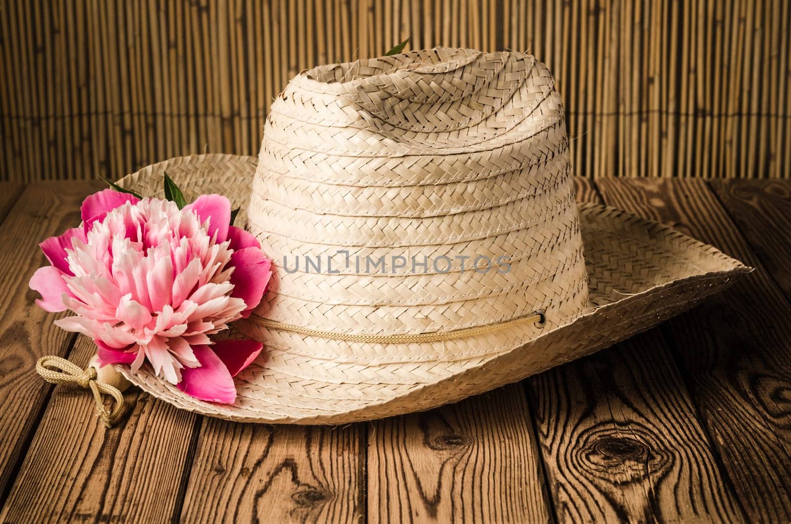 Straw hat and peony flower, close-up