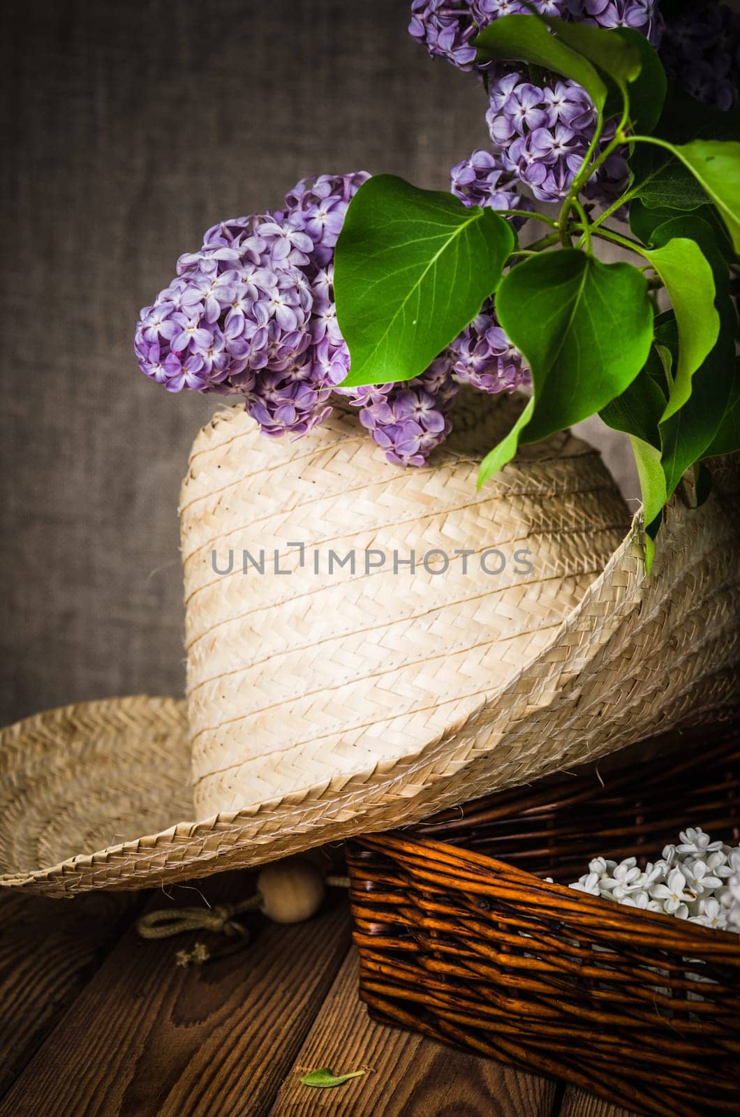 Still-life with a bouquet of lilacs and a straw hat, close-up