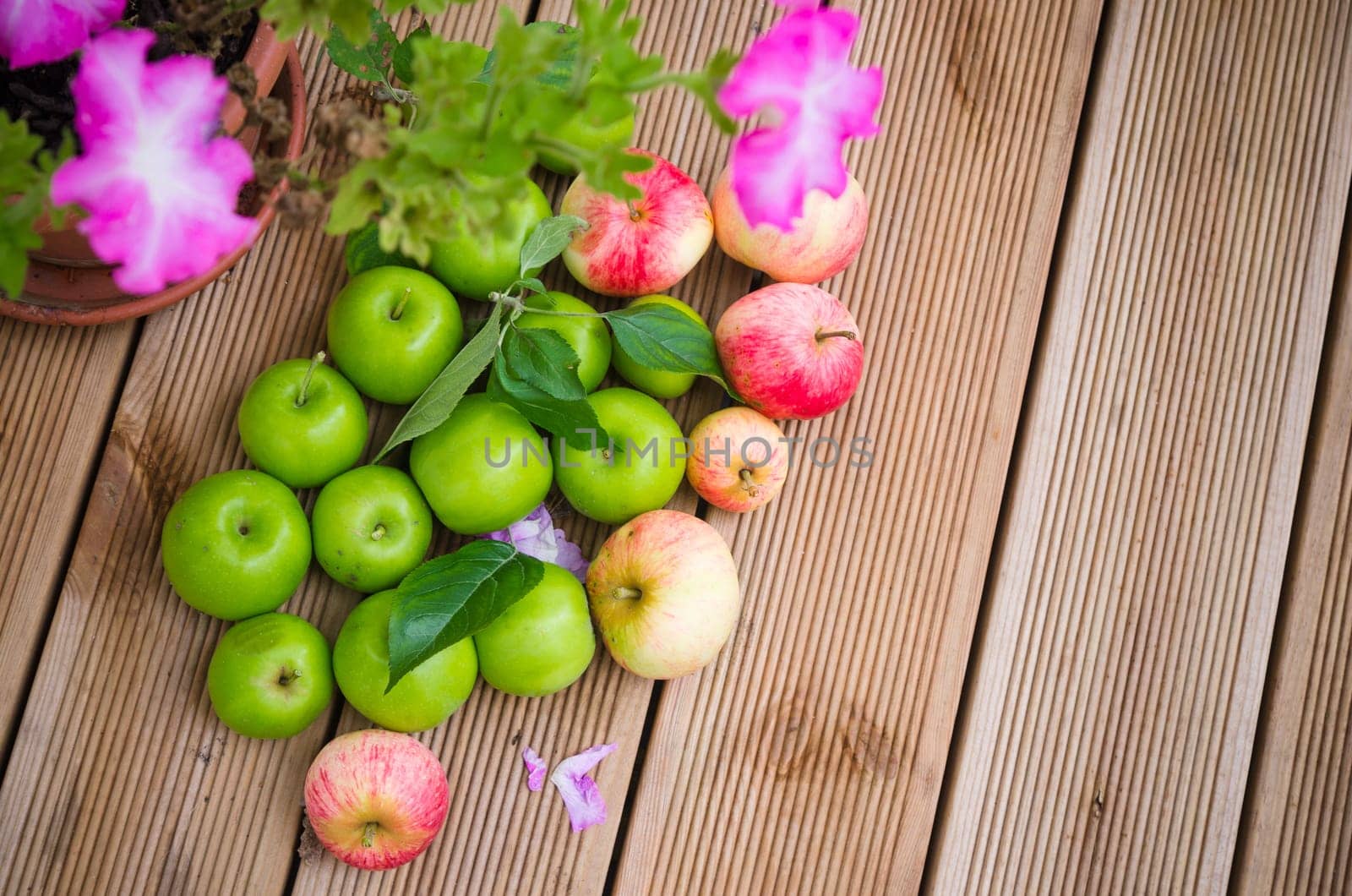 Ripe apples with a leaf on a wooden surface, top view